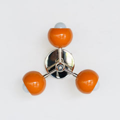 mid century modern sconce with orange shades and chrome hardware