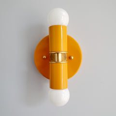 Orange and Brass two light wall sconce or flush mount ceiling light fixture in a bright vibrant color and mid century modern or art deco design