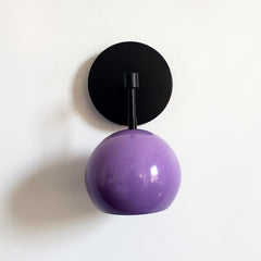 Black and purple midcentury inspired wall sconce with a globe shade