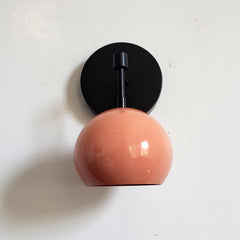 Black and peach midcentury inspired wall lighting sconce with globe shade
