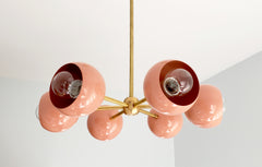 Peachy coral chandelier with brass accents and globe shades midcentury modern style updated