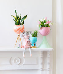Pastel mantle for easter with colorful planters, eggs, and a bunny