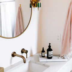 Pink bathroom with brass accents and marble countertop