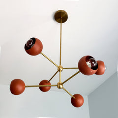 Terra Cotta colored chandelier with brass hardware by Sazerac Stitches