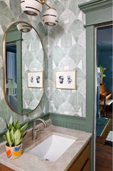 Organic modern two light wall sconce with speckled ceramic shades that have an accent line around the perimeter.  Featured in a traditional organic inspired bathroom with green geometric patterns wallpaper
