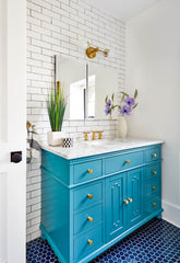 Colorful bathroom renovation with white subway tile, turquoise vanity, and cobalt blue flooring