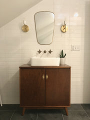 Midcentury modern bathroom featuring an old cabinet, retro decor, and Camp sconces by Sazerac stitches