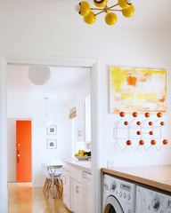 Yellow and brass Loa Carousel flushmount ceiling light in a mid century modern laundry room