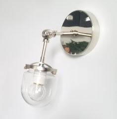 articulating wall sconce in chrome with a clear glass globe shade and one wall light