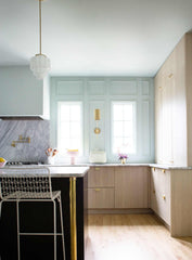 pale wood and pastel blue kitchen renovation with modern cabinetry, brass details, and art deco inspired  pendant lighting