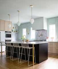 pale wood and pastel blue kitchen renovation with modern cabinetry, brass details, and art deco inspired  pendant lighting