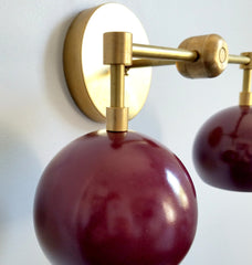 close up picture of brass black cherry double loa wall sconce