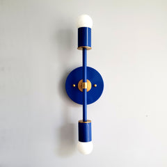 Bright blue two light ceiling light fixture or wall sconce with brass accents. Colorful modern lighting design.