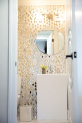 modern glam bathroom with mirrored tile and chrome light fixture